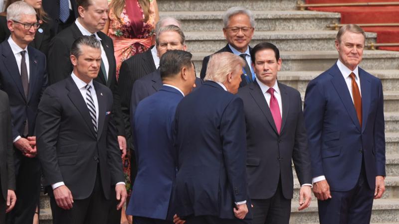 Trump con il presidente cinese Xi Jinping presso la Grande Sala del Popolo&nbsp;a Pechino, mentre il segretario alla Difesa Pete Hegseth, il segretario al Tesoro Scott Bessent, il segretario di Stato Marco Rubio, l&rsquo;amministratore delegato di Apple Tim Cook, Elon Musk e l&rsquo;amministratore delegato di Nvidia Jensen Huang osservano la scena.
