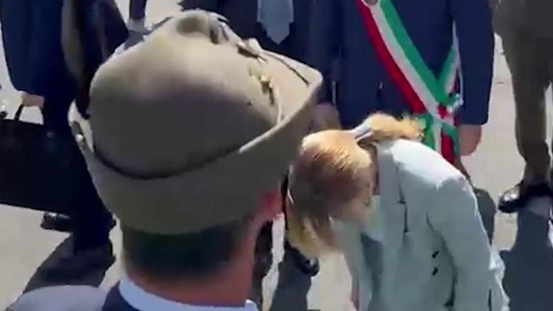 Meloni china il capo davanti al labaro degli alpini