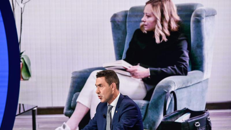 Nella foto Roberto Vannacci e sullo schermo la premier Giorgia Meloni
