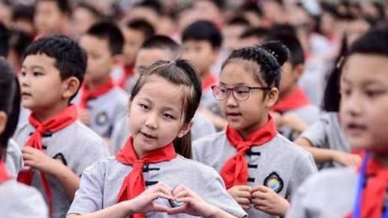Strada commerciale affollata in città cinese con negozi e persone, contrapposta a aula scolastica vuota con banchi abbandonati, immagine di approfondi