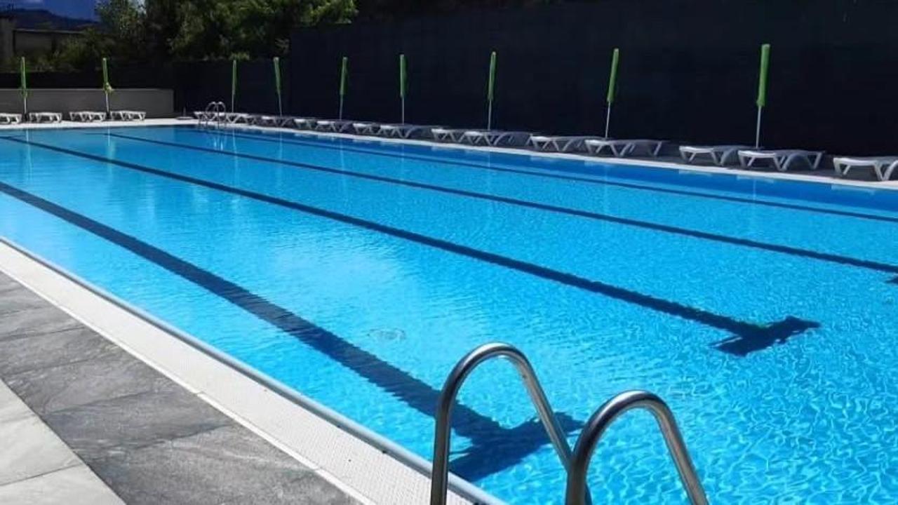 Stabilimento balneare con piscina, mezzi di soccorso in azione, ambulanza e elicottero d'emergenza, immagine di approfondimento