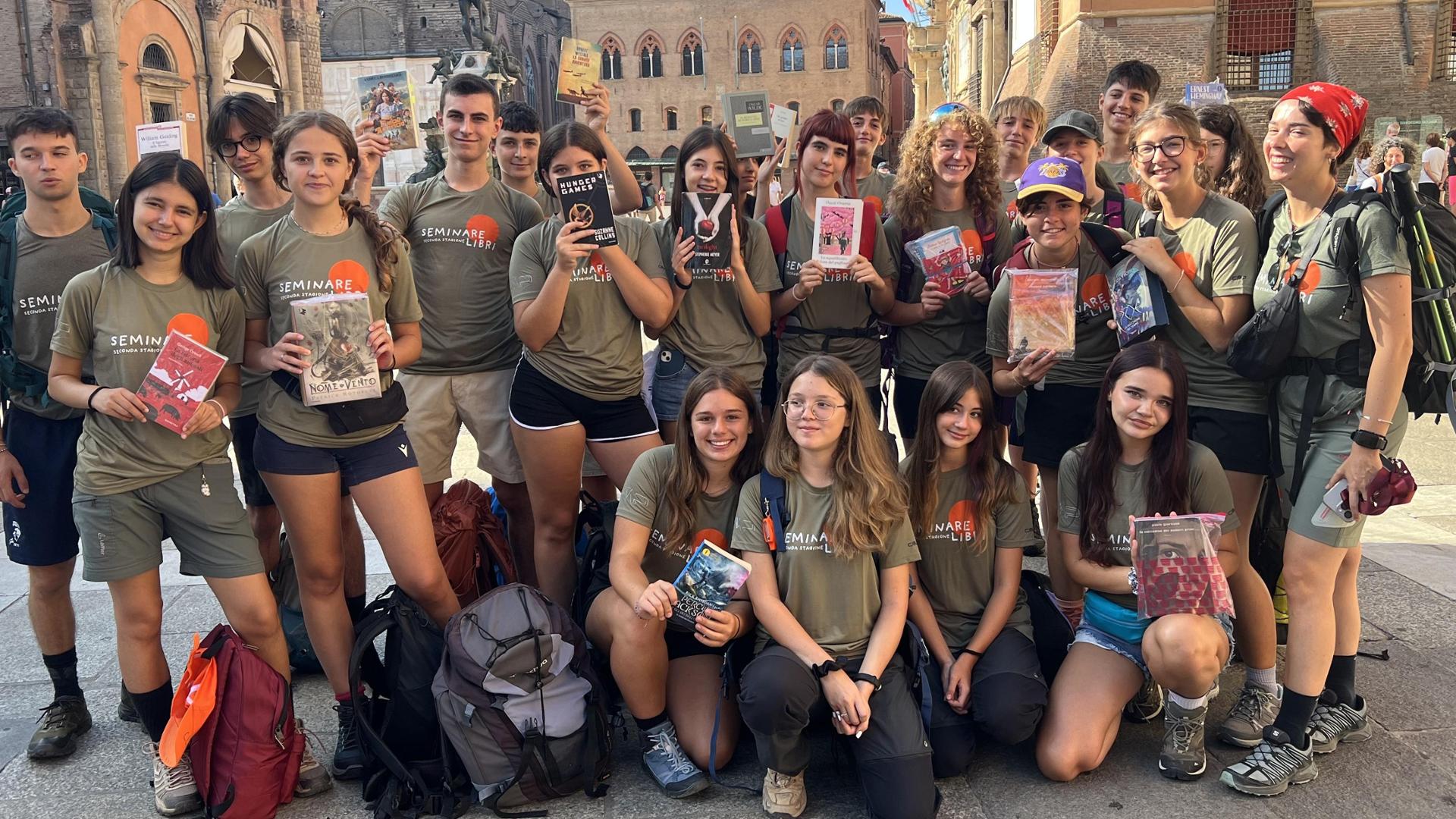 Gruppo di adolescenti cammina lungo la Via degli Dei, portando libri da condividere con altri lettori