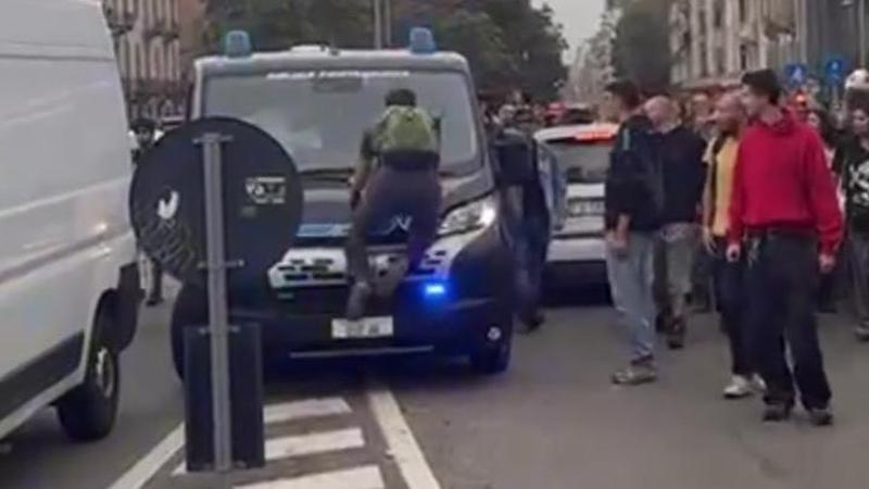 Antagonista salta sul furgone della polizia: lo scatto del mezzo e la fuga dei manifestanti