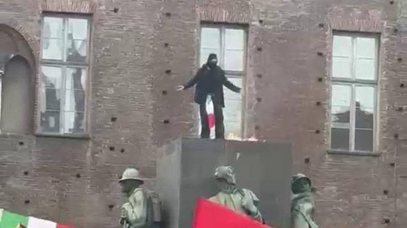 Torino, sale sul monumento e brucia la foto di Giorgia Meloni: la scena in Piazza Castello